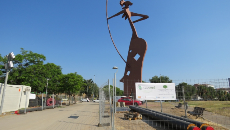 Imatge de l'escultura de Laia l'Arquera amb conduccions de TubVerd en primer pla i lona 